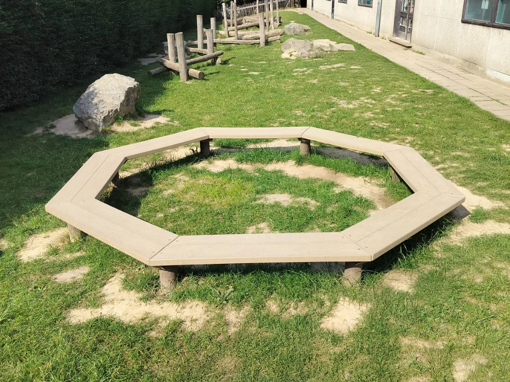 achthoekbank in schooltuin op gras.webp