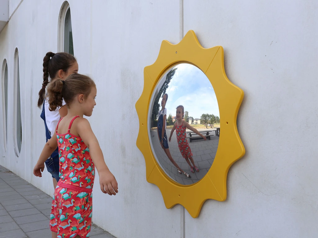Bolle spiegel speelplaats tegen muur.webp