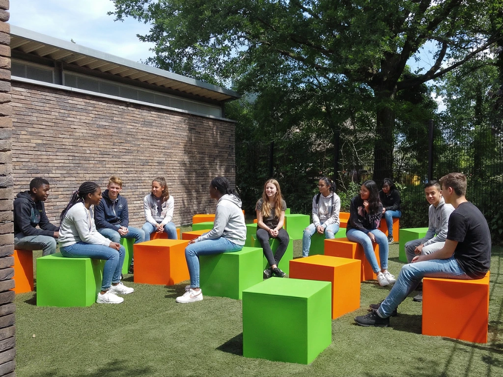 Secondary_school_students_on_coloured_cubes.webp