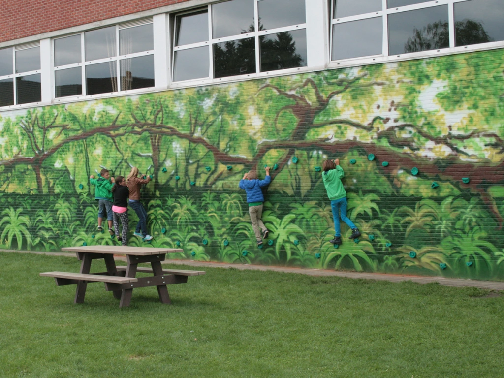 boulderwand met muurschildering op school.webp